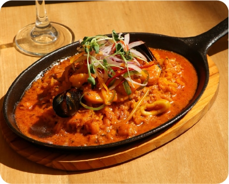 Seafood in sauce served in a cast-iron pan
