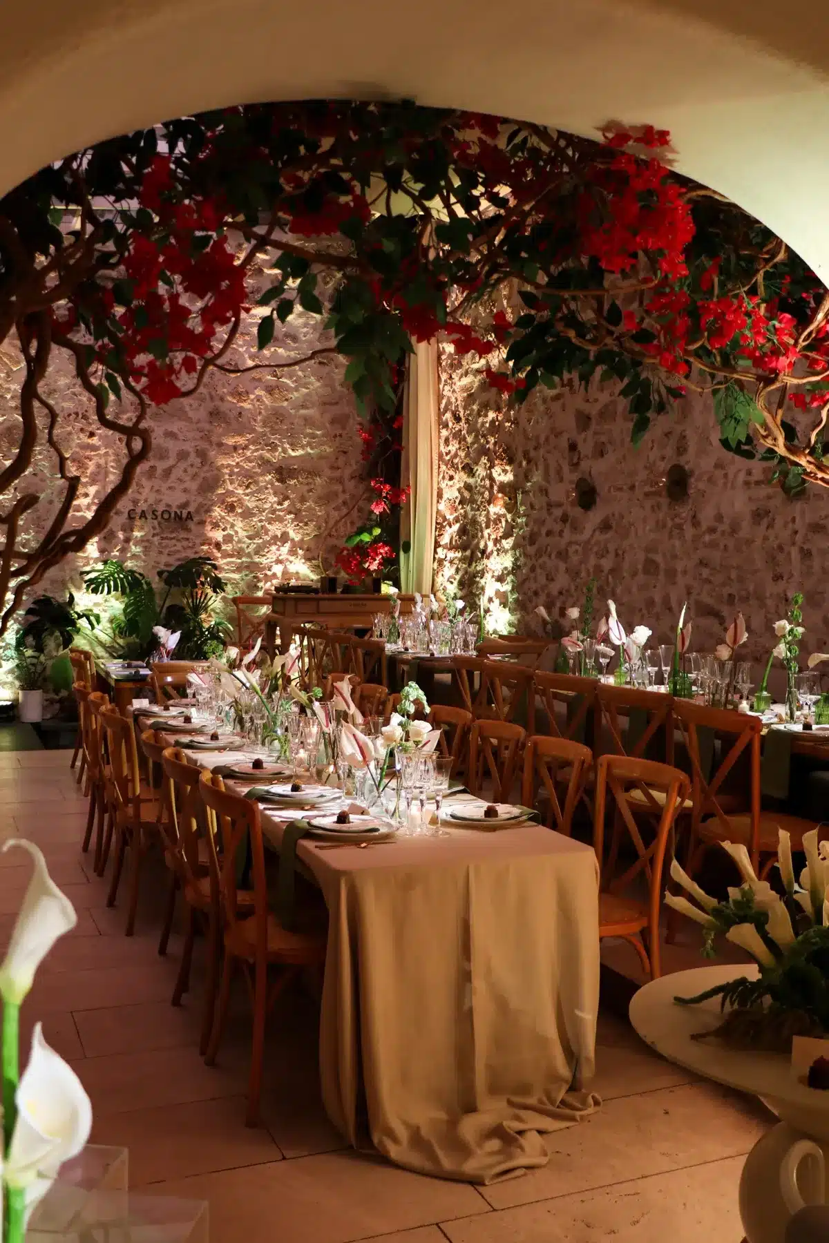The courtyard set for a private event, with a long table and bougainvillea