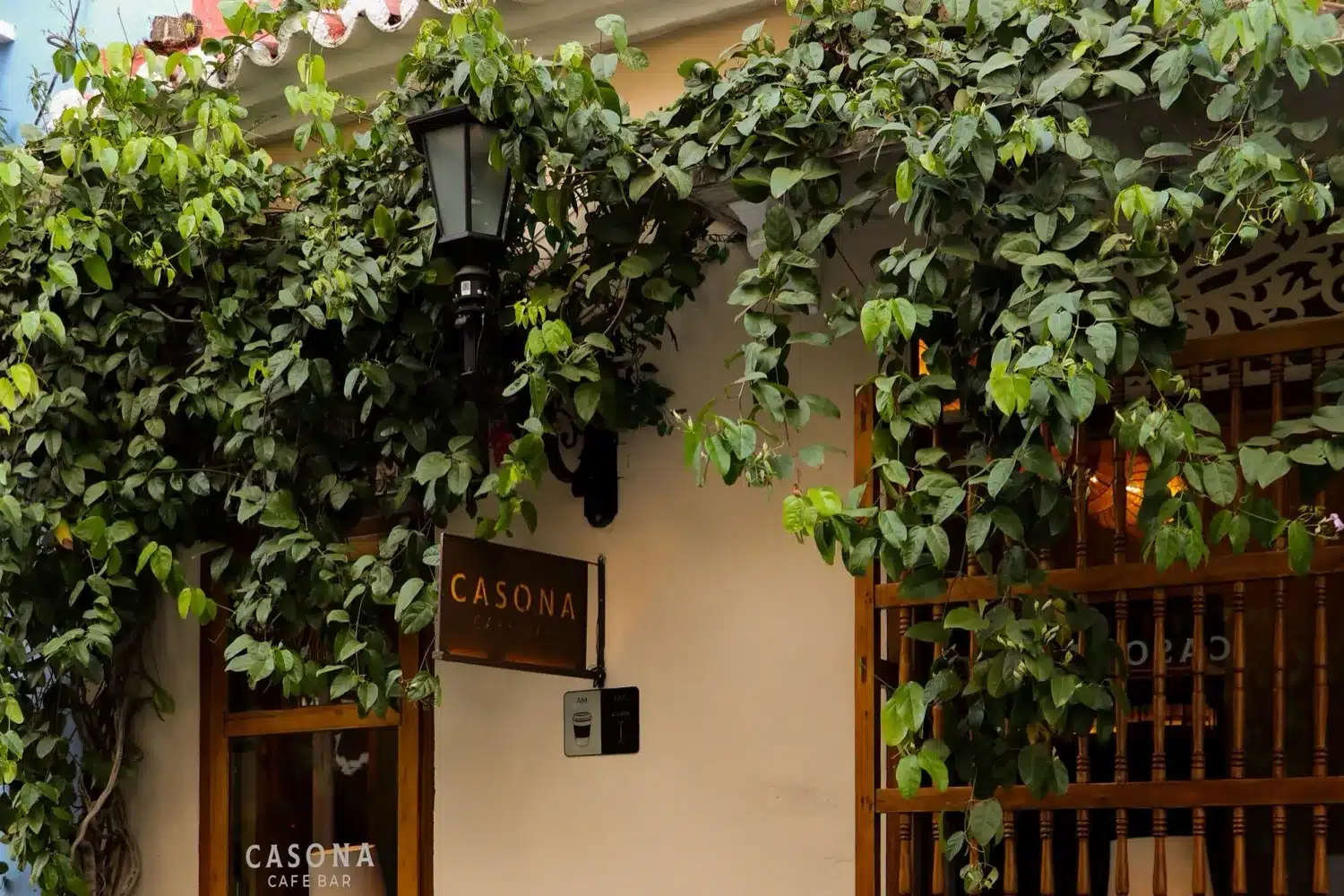 Casona Café Bar's façade on Calle del Curato, with its sign and climbing vines